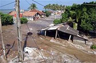 Tidal waves wash through houses at Maddampegama. Massive waves triggered by earthquakes crashed into villages along a wide stretch of Sri Lankan coastline on Sunday, killing more than 14,800 people and displacing a million others.