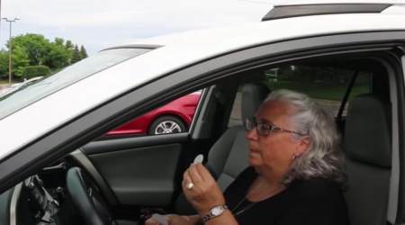 A woman takes pre-packaged Holy Communion out of Pax Christi parish and consumes it in her car during a parish promotional video