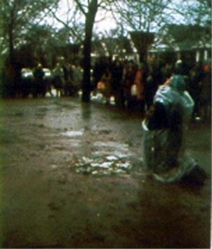 Veronica kneels in the mud at a Bayside Holy Hour in 1974 in front of the exact location where the miraculous spring of water will erupt. Afterwards people placed their rosaries on the sacred spot.